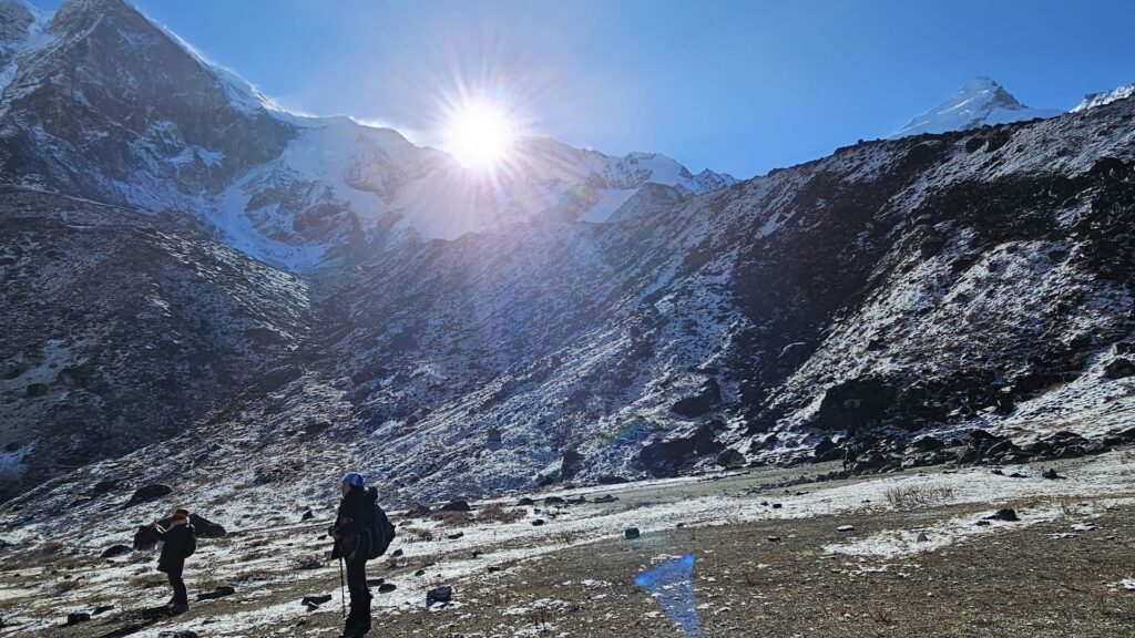 Trekkers walking on the Sandakphu Phalut trek ridge with views of Kanchenjunga and Everest range at sunrise